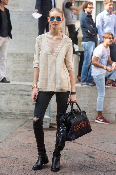 Light pink sweater with a deep V-neckline, black jeans and short boots