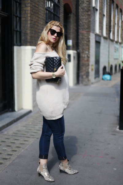 Light pink oversized one shoulder knit sweater and black cropped maternity jeans
