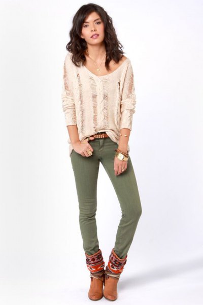 Light pink, torn long-sleeved shirt with olive-green skinny jeans