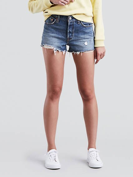 Light yellow chunky sweatshirt with blue Levis denim shorts and white sneakers