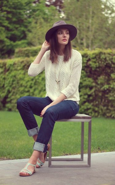 Light yellow knitted sweater with dark blue slim fit jeans with cuffs and white sandals