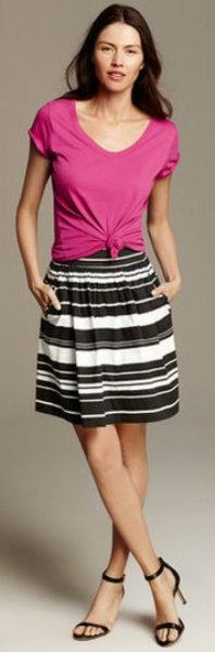 pink knotted t-shirt with scoop neckline and black and white striped knee-length skirt
