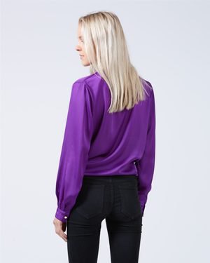 purple shirt with puff sleeves and dark blue skinny jeans