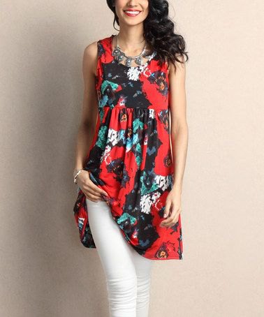 red and black tunic top with floral pattern and white skinny jeans