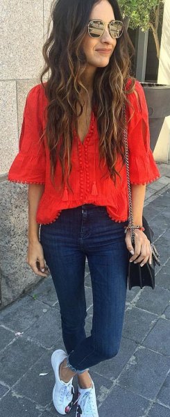 red blouse with V-neckline and dark blue skinny jeans