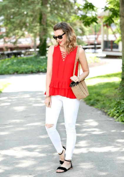 Red sleeveless blouse with a V-neckline and white ripped front with white jeans