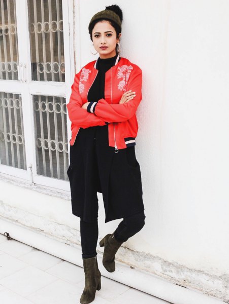 red embroidered bomber jacket with black sweater with a round neckline and skinny jeans