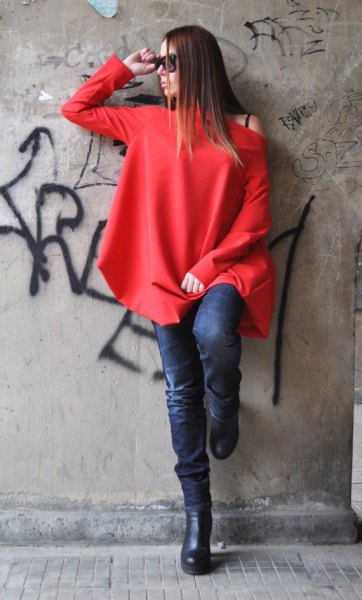 red long-sleeved top with one shoulder and dark blue skinny jeans