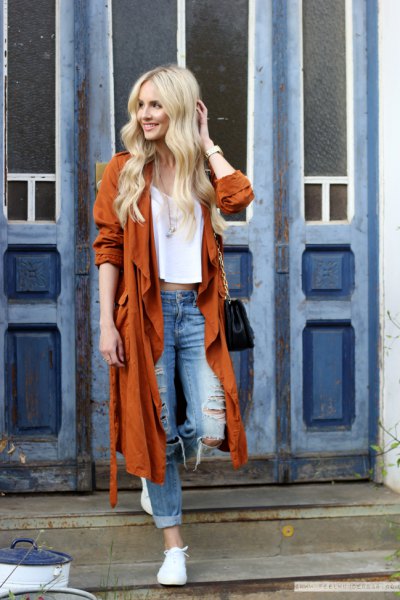 red longline trench coat with torn boyfriend jeans and white sneakers