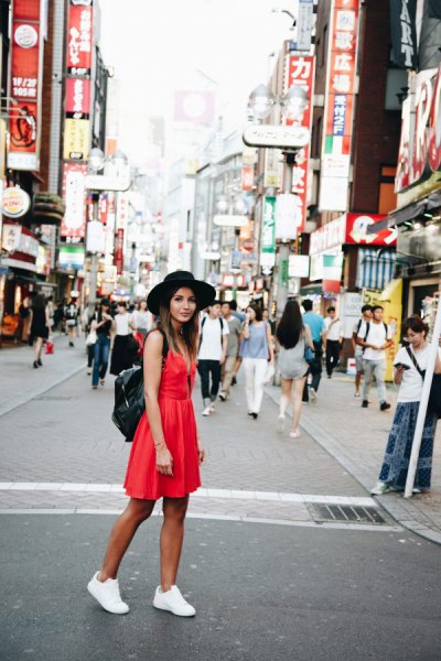 red mini summer dress with white sneakers and black felt hat