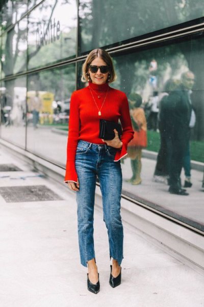 red bell-sleeved sweater with blue neckline and blue-cut jeans with straight legs