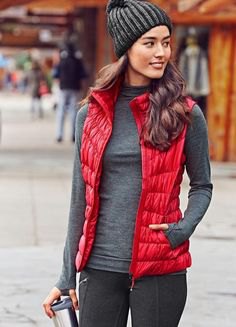 red nylon vest with gray knitted hat and gray sweater