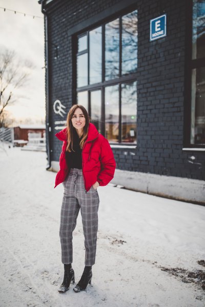 red padded jacket with black mock-neck sweater and checked, cropped trousers