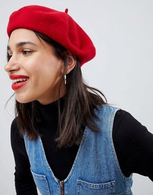 red painter's hat with black mock-neck sweater and blue denim dress with V-neck
