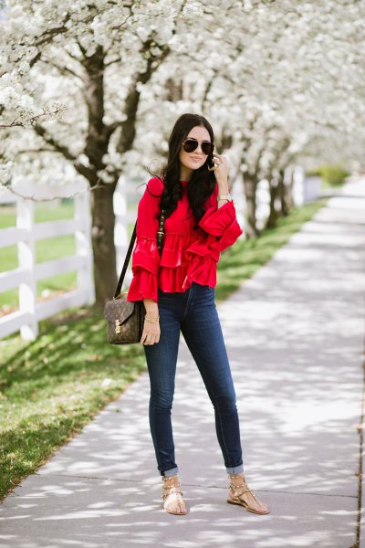 Skinny jeans with a red ruffled blouse and cuff
