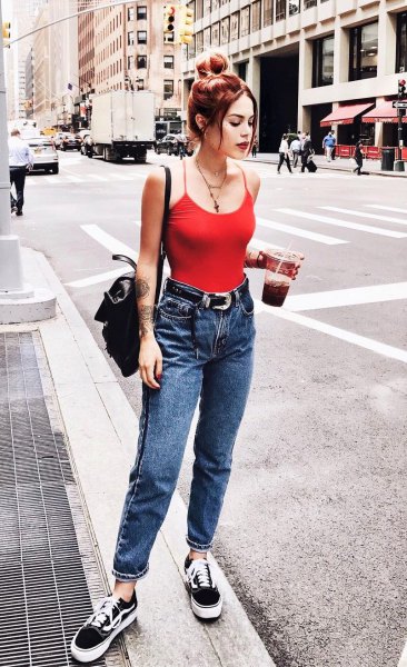 red tank top with scoop neckline, blue jeans with cuffs and canvas shoes