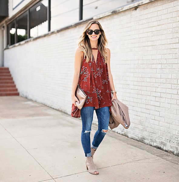 Red sleeveless tunic with a V-neckline and blue ribbed skinny jeans