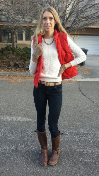 red waistcoat with white knitted sweater with round neckline and black skinny jeans