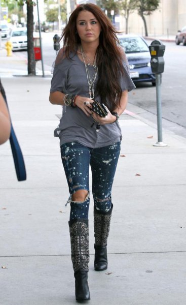 Skinny jeans with ripped paint and knee-high boots made of black leather
