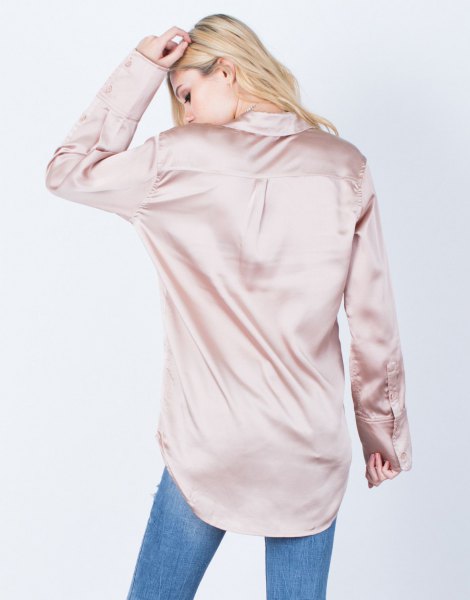 Rose gold oversized silk shirt with buttons and blue jeans