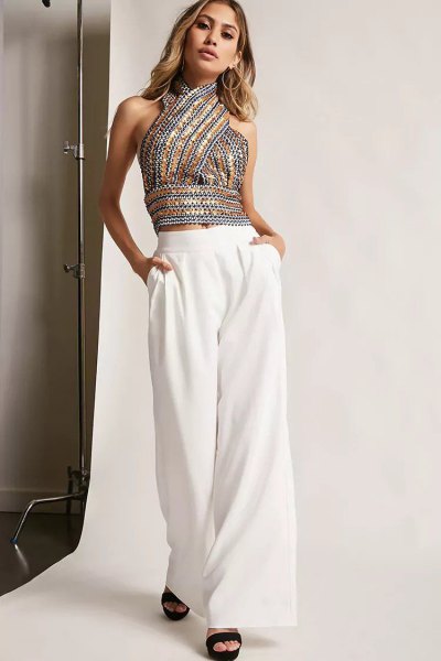 Sequin halter top with silver and gold pattern and white trousers with wide legs