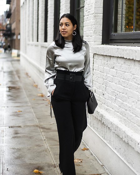 silver metallic blouse with black trousers with a high waist and wide legs