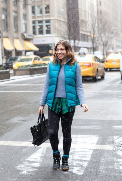 blue-green sweater with sky-blue vest and black leggings