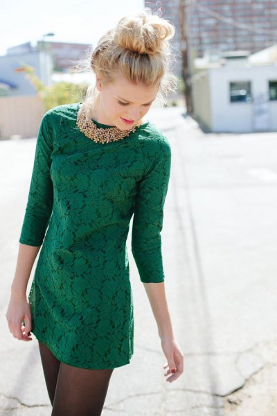 dark green lace mini dress with three-quarter sleeves and gold necklace