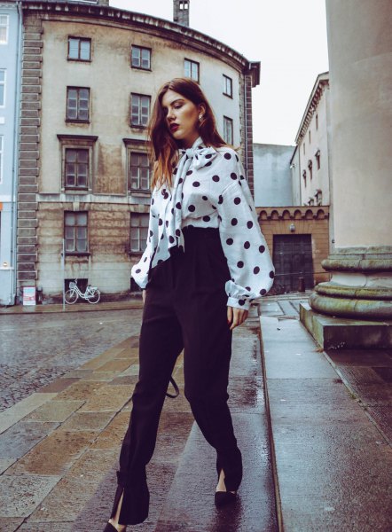 white and black polka dot blouse with a polka dot tie on the front and high pants