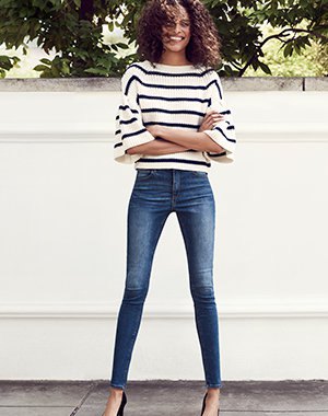 white and black striped wide-sleeved sweater and blue skinny jeans