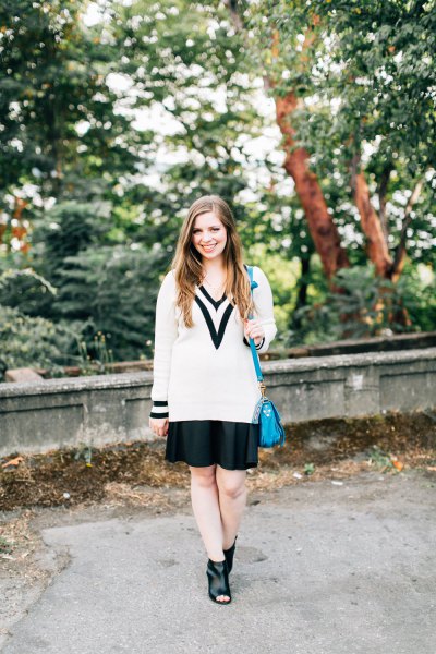Chunky sweater with white and black V-neckline and mini pleated skirt