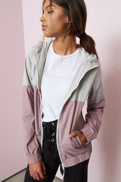 white and light gray color block Nike windbreaker with black lace-up jeans