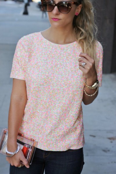 Short-sleeved blouse with a white and peach-colored pattern and black skinny jeans