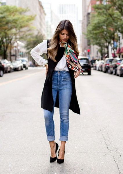 white shirt with buttons, black long vest and blue jeans with high waist
