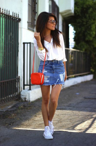 white shirt with buttons, a blue torn minirim skirt and a small brown shoulder bag