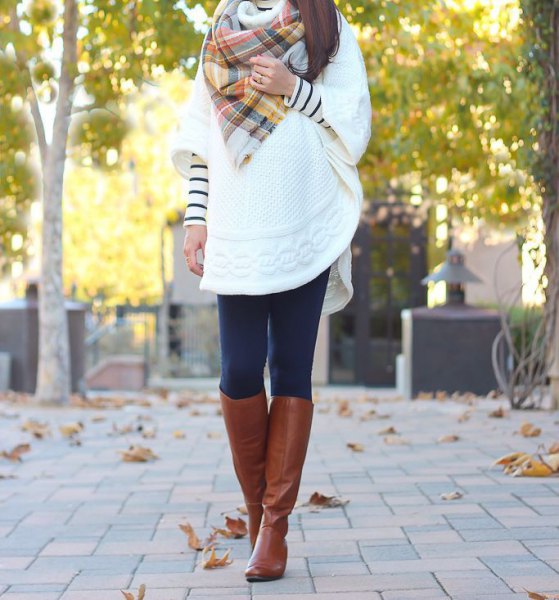 white cable knit cape with checked scarf and knee-high boots made of brown leather