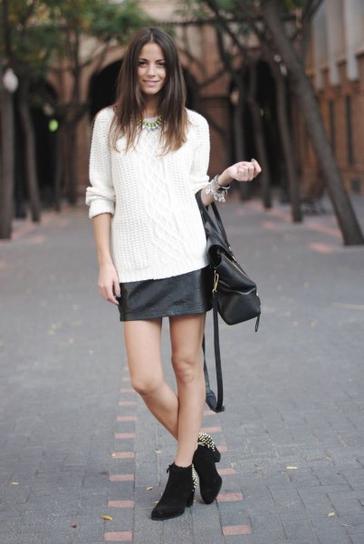white cable knit sweater with black leather skirt and mini boots with heels