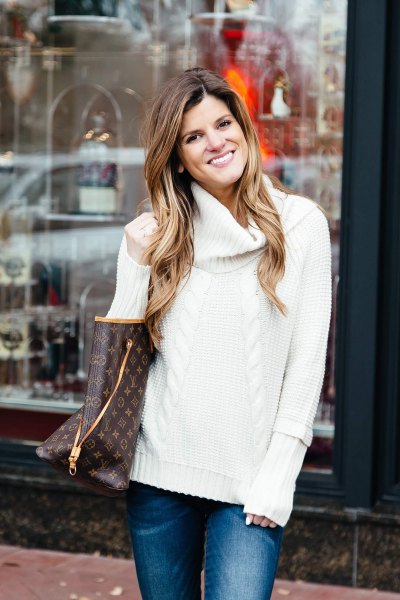 white cable knit sweater with blue slim fit jeans