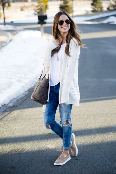 white cardigan with blue ripped jeans with cuffs and gray slip on hiking boots