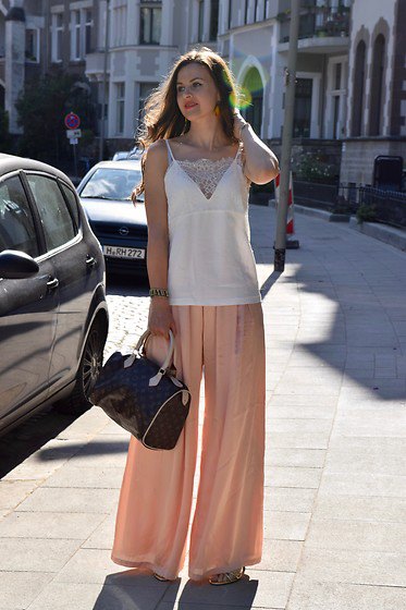 sleeveless top made of white chiffon and blushing trousers with wide legs
