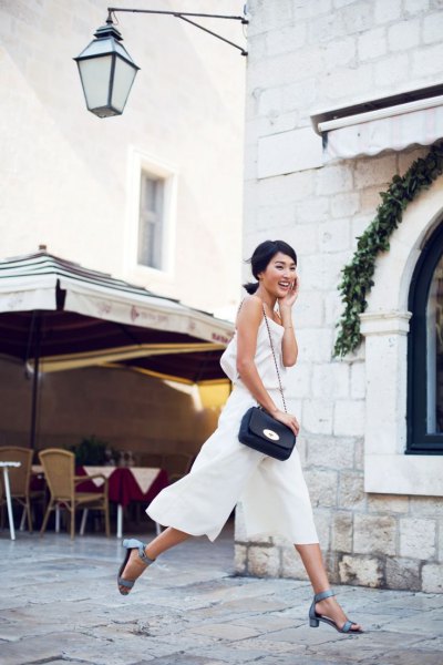 sleeveless top made of white chiffon with matching trousers with wide legs and gray heels