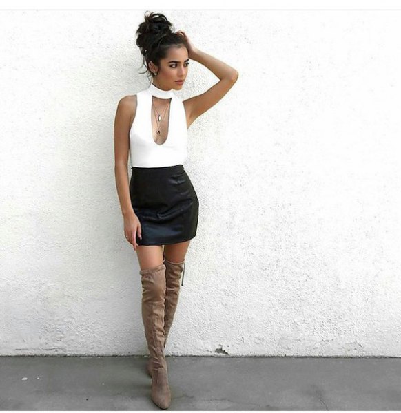 white, low-cut, sleeveless top with choker neckline and black mini skirt