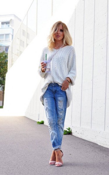 white, grainy knitted sweater with blue ripped jeans with cuffs