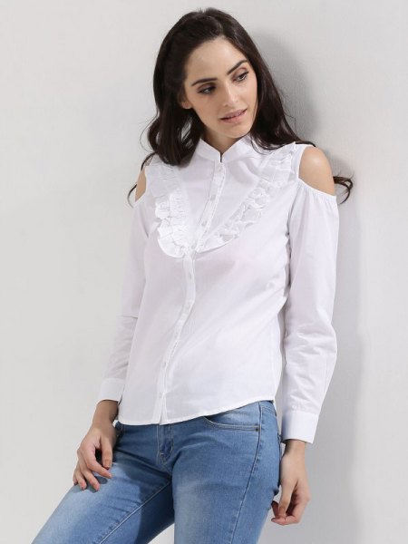 white shirt with ruffles on the front and light blue skinny jeans