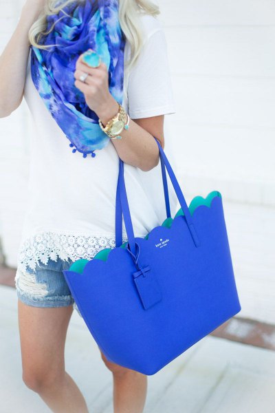 white crochet t-shirt with denim shorts and royal blue handbag