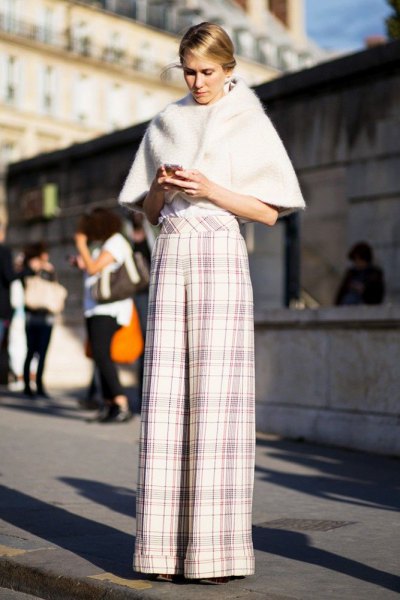 white faux fur cape with plaid palazzo trousers