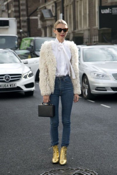 white faux fur jacket with a white bow tie and gold boots
