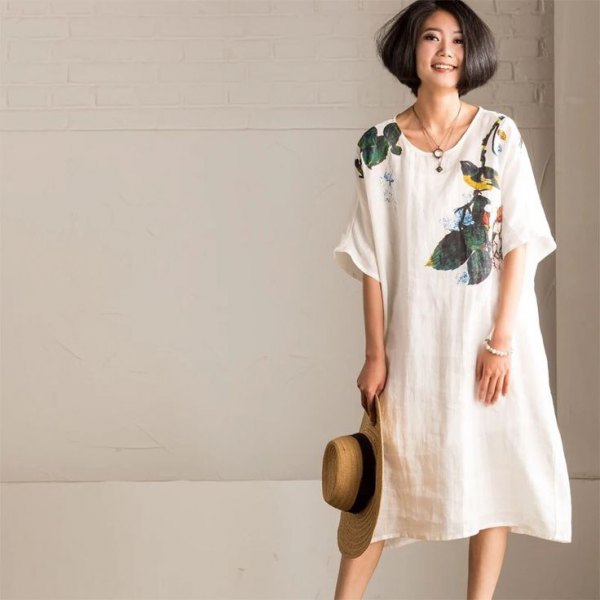 white swing dress made of linen with a floral pattern