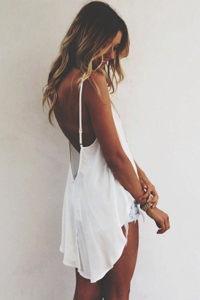 white flowing backless high-low tank top with denim shorts