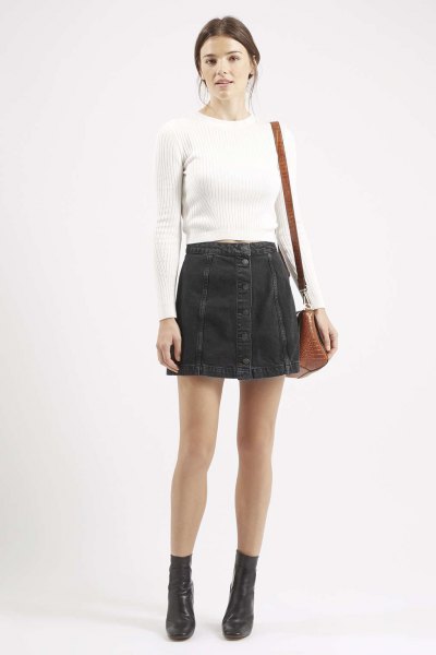 white, figure-hugging, ribbed sweater with black denim mini skirt with button placket
